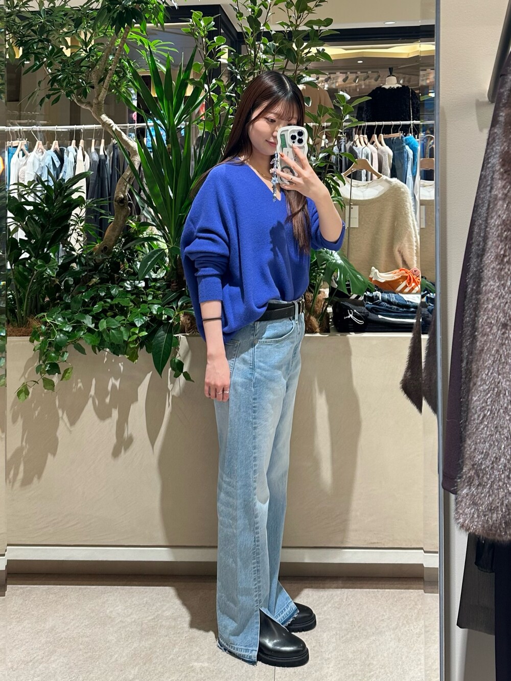 ブルー系のニット/セーター、ブルー系のデニムパンツ、ブラック系のブーツを着用したレディースの冬コーディネートの3枚目の写真