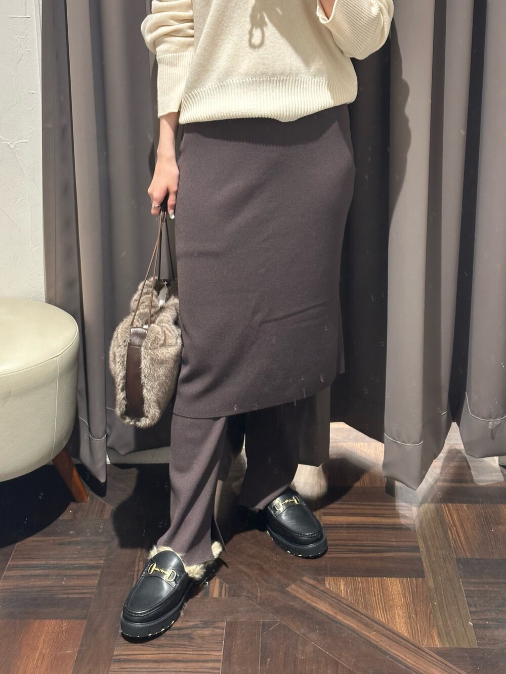 ブラウン系のその他パンツ、ホワイト系のニット/セーター、ブラウン系のハンドバッグを着用したレディースの秋コーディネートの2枚目の写真