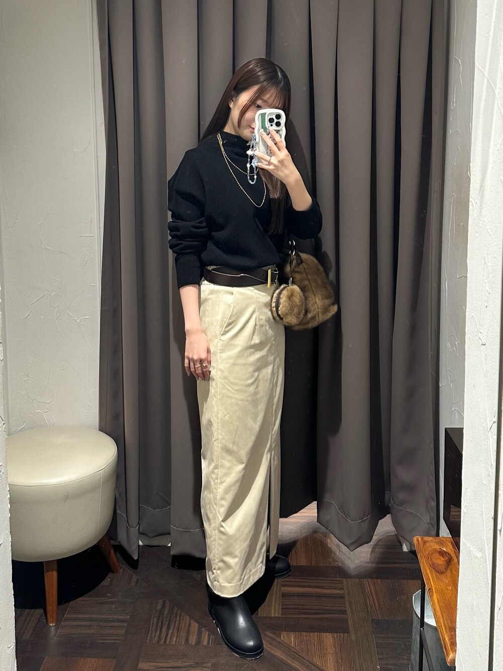 ブラック系のニット/セーター、ベージュ系のスカート、イエロー系のハンドバッグを着用したレディースの秋コーディネートの4枚目の写真