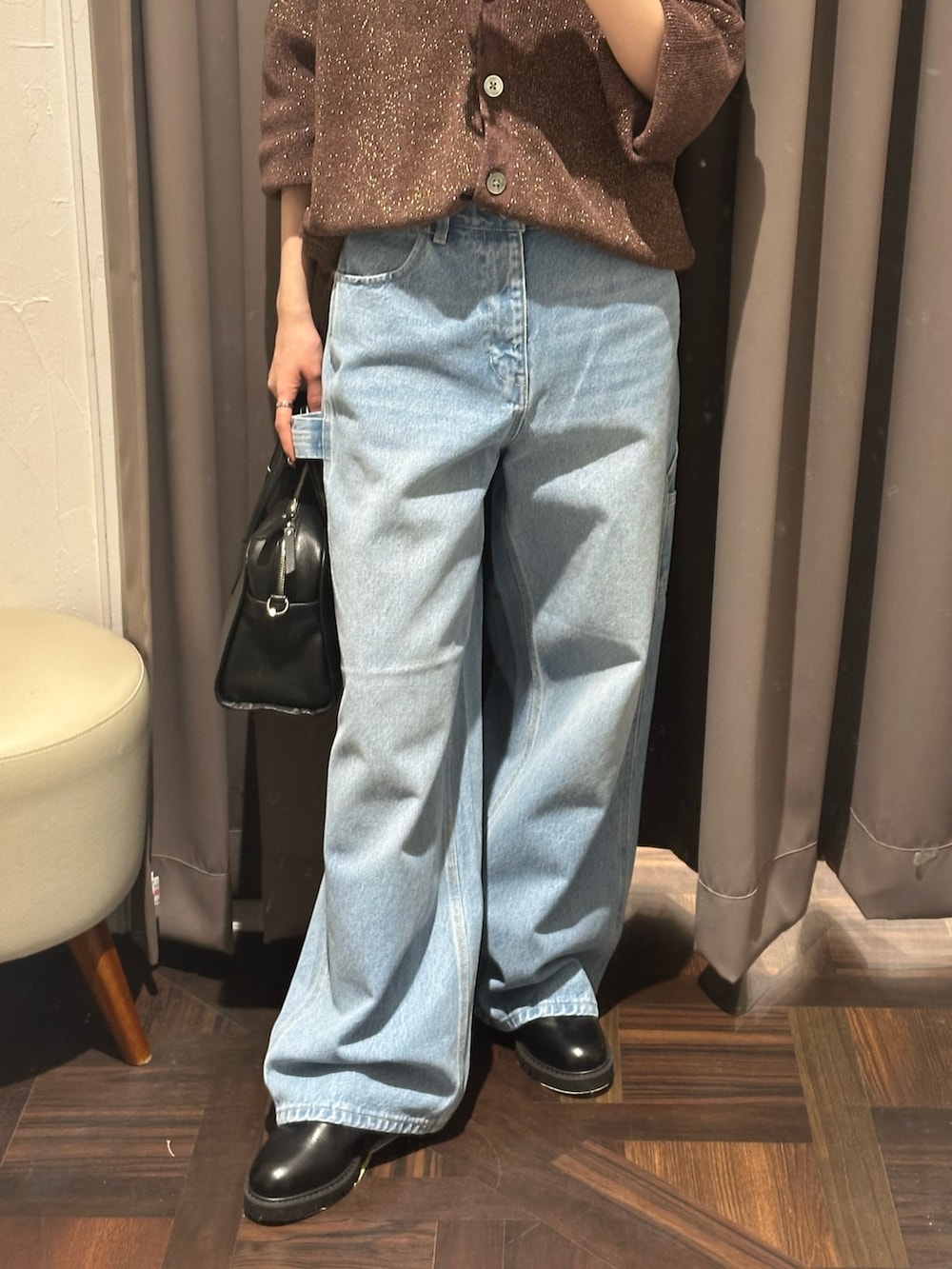 ブラウン系のニット/セーター、ブラック系のブーツ、ブルー系のデニムパンツを着用したレディースの秋コーディネートの3枚目の写真