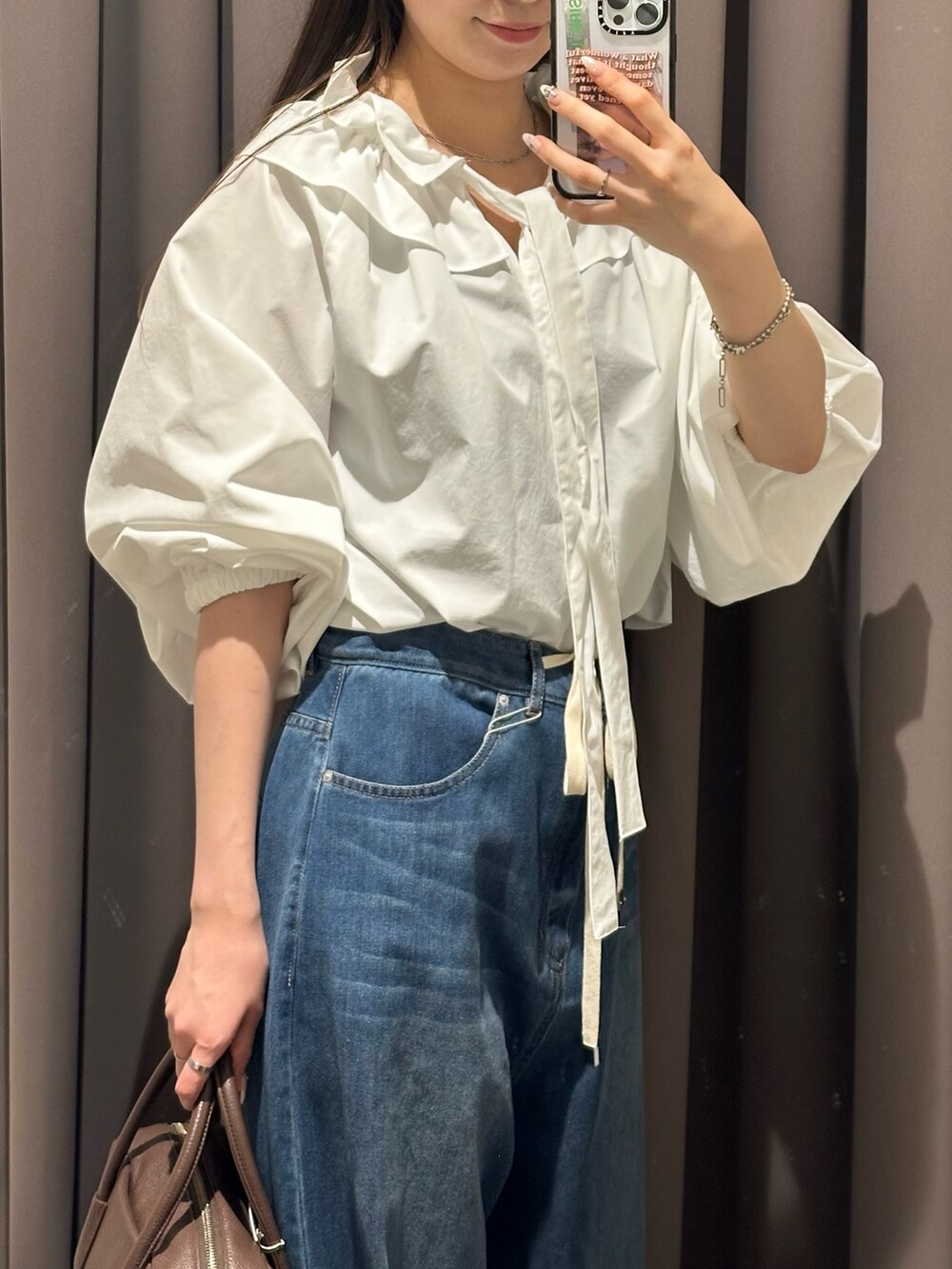 ブルー系のデニムパンツ、ブラック系のその他シューズ、ホワイト系のシャツ/ブラウスを着用したレディースの夏コーディネートの5枚目の写真