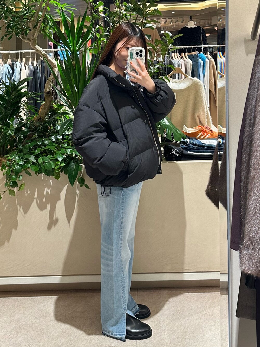 ブルー系のニット/セーター、ブルー系のデニムパンツ、ブラック系のダウンジャケット/コートを着用したレディースの冬コーディネートの3枚目の写真