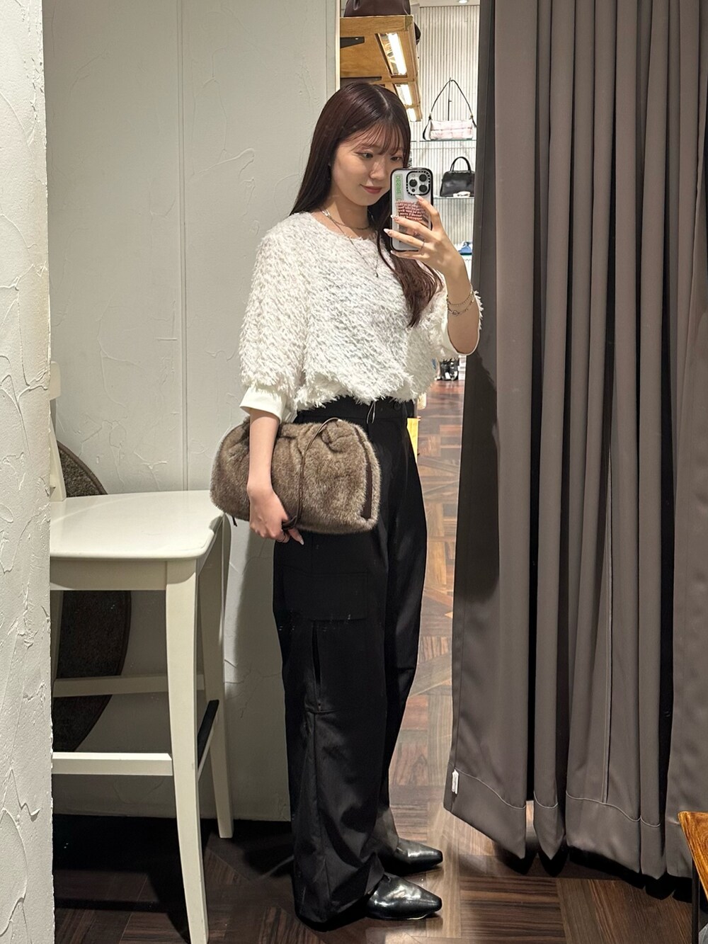 ブラウン系のカーゴパンツ、ホワイト系のシャツ/ブラウス、ブラウン系のハンドバッグを着用したレディースの秋コーディネートの4枚目の写真