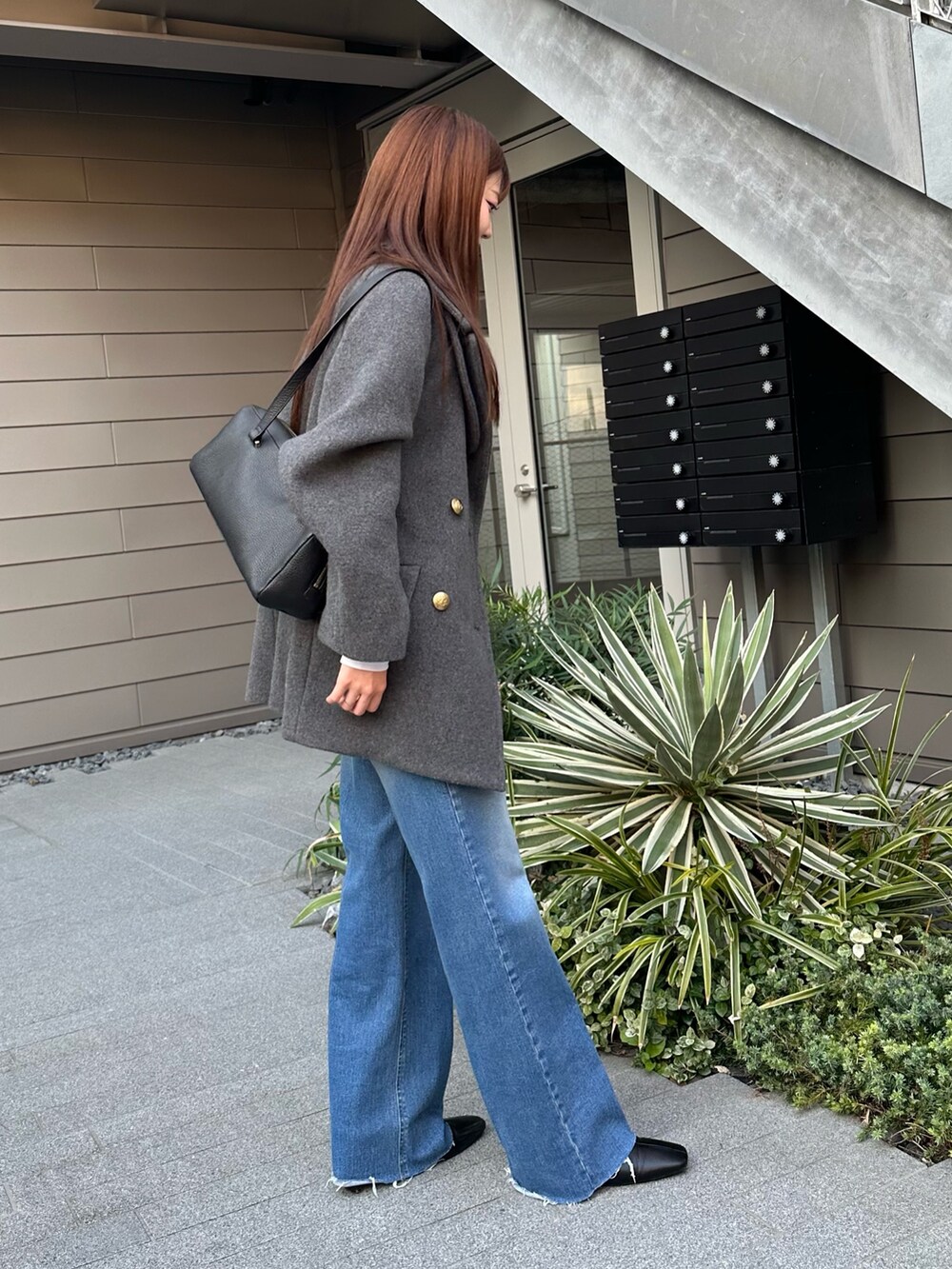 グレー系のピーコート、ブルー系のデニムパンツ、ブラウン系のブーツを着用したレディースの秋コーディネートの3枚目の写真