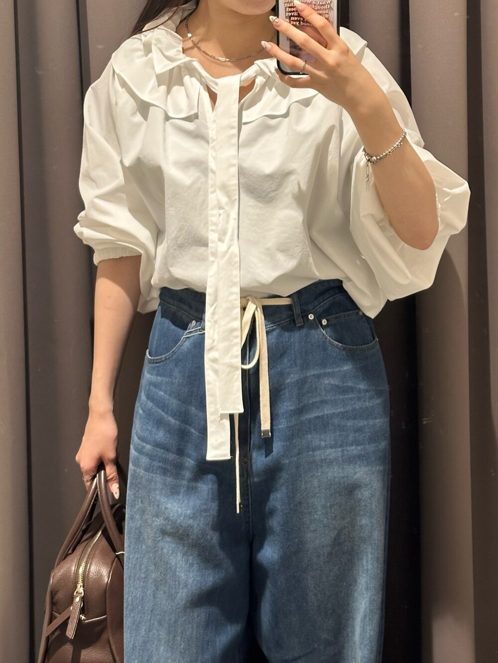 ブルー系のデニムパンツ、ブラック系のその他シューズ、ホワイト系のシャツ/ブラウスを着用したレディースの夏コーディネートの3枚目の写真