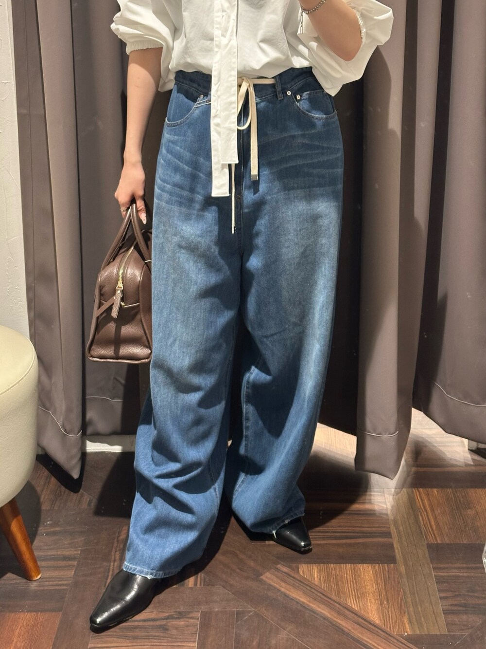 ブルー系のデニムパンツ、ブラック系のその他シューズ、ホワイト系のシャツ/ブラウスを着用したレディースの夏コーディネートの2枚目の写真