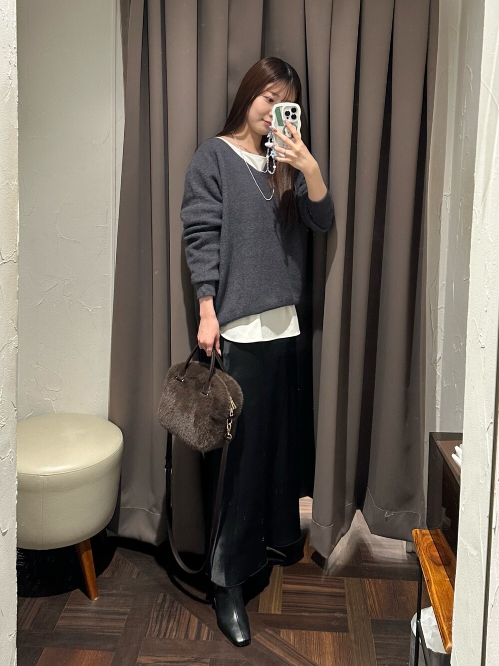 グレー系のニット/セーター、ホワイト系のTシャツ/カットソー、ブラック系のスカートを着用したレディースの冬コーディネートの4枚目の写真