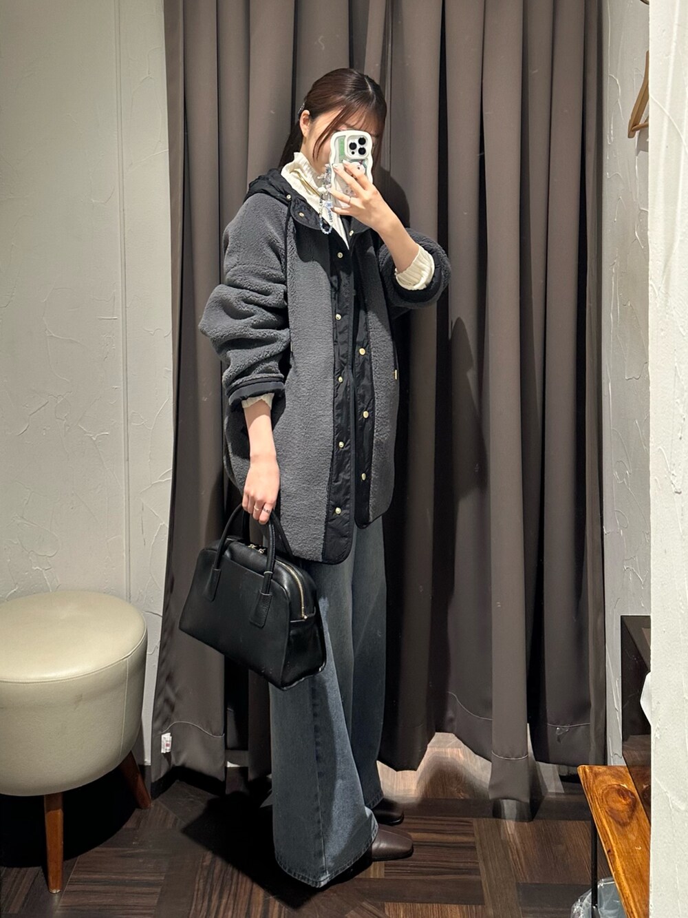 ブルー系のデニムパンツ、グレー系のその他アウター、ブラック系のボストンバッグを着用したレディースの秋コーディネートの4枚目の写真