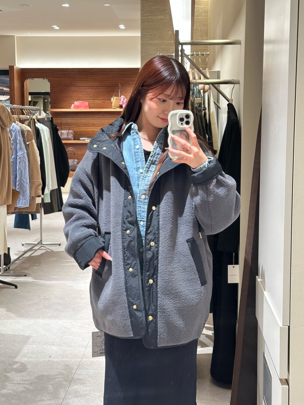 ブラック系のワンピース、グレー系のその他アウター、ベージュ系のブーツを着用したレディースの冬コーディネートの2枚目の写真