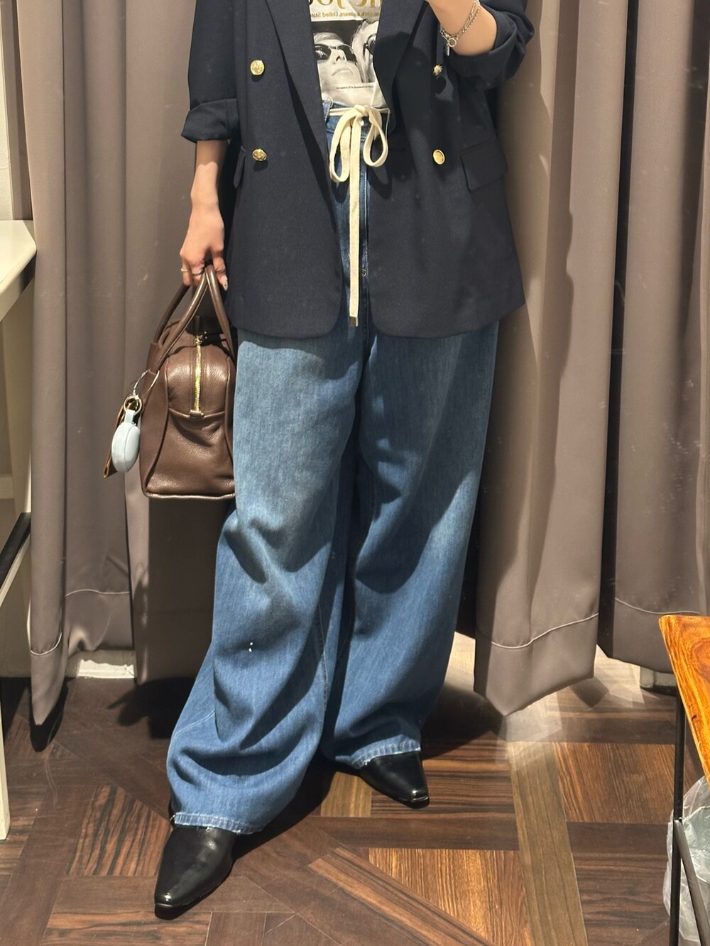 ブルー系のデニムパンツ、ブルー系のテーラードジャケット、ブラウン系のボストンバッグを着用したレディースの夏コーディネートの3枚目の写真