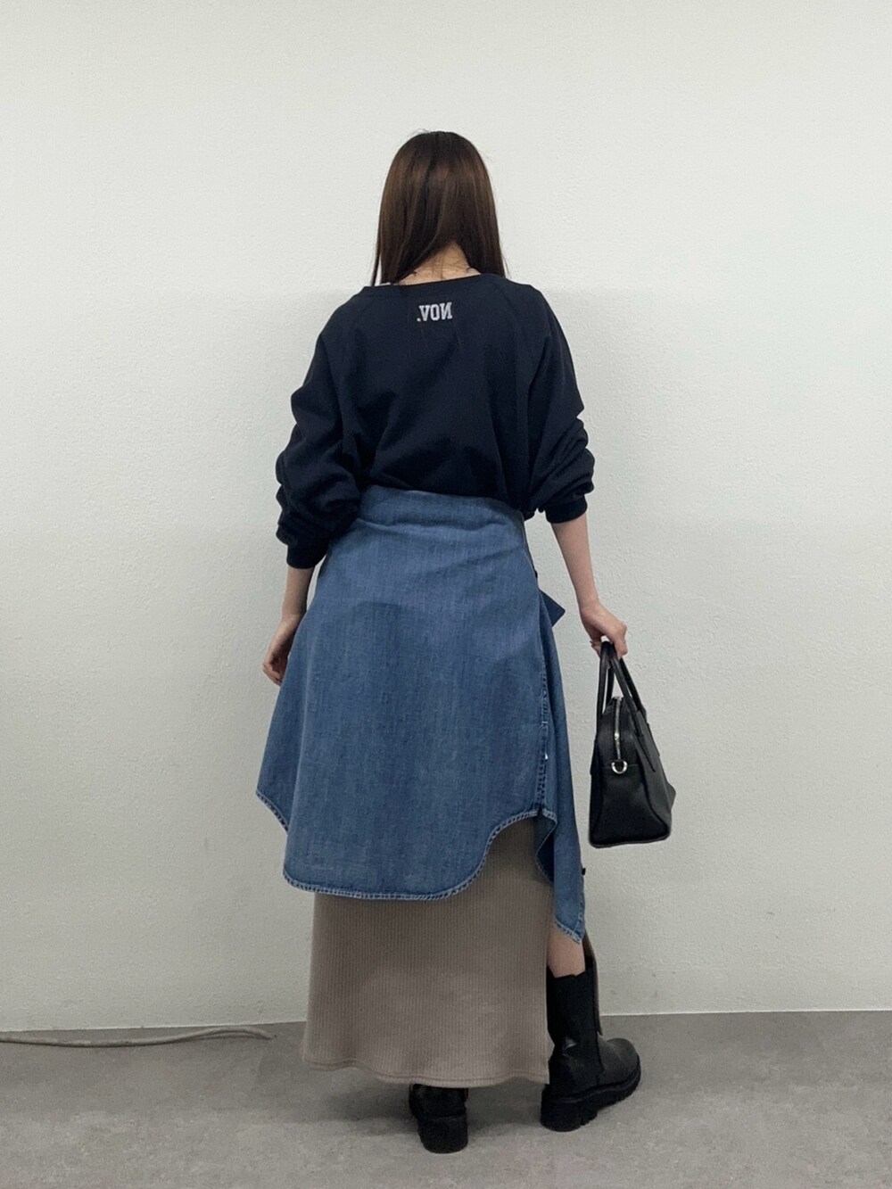 ベージュ系のワンピース、ブラック系のブーツ、ブラック系のボストンバッグを着用したレディースの秋コーディネートの3枚目の写真