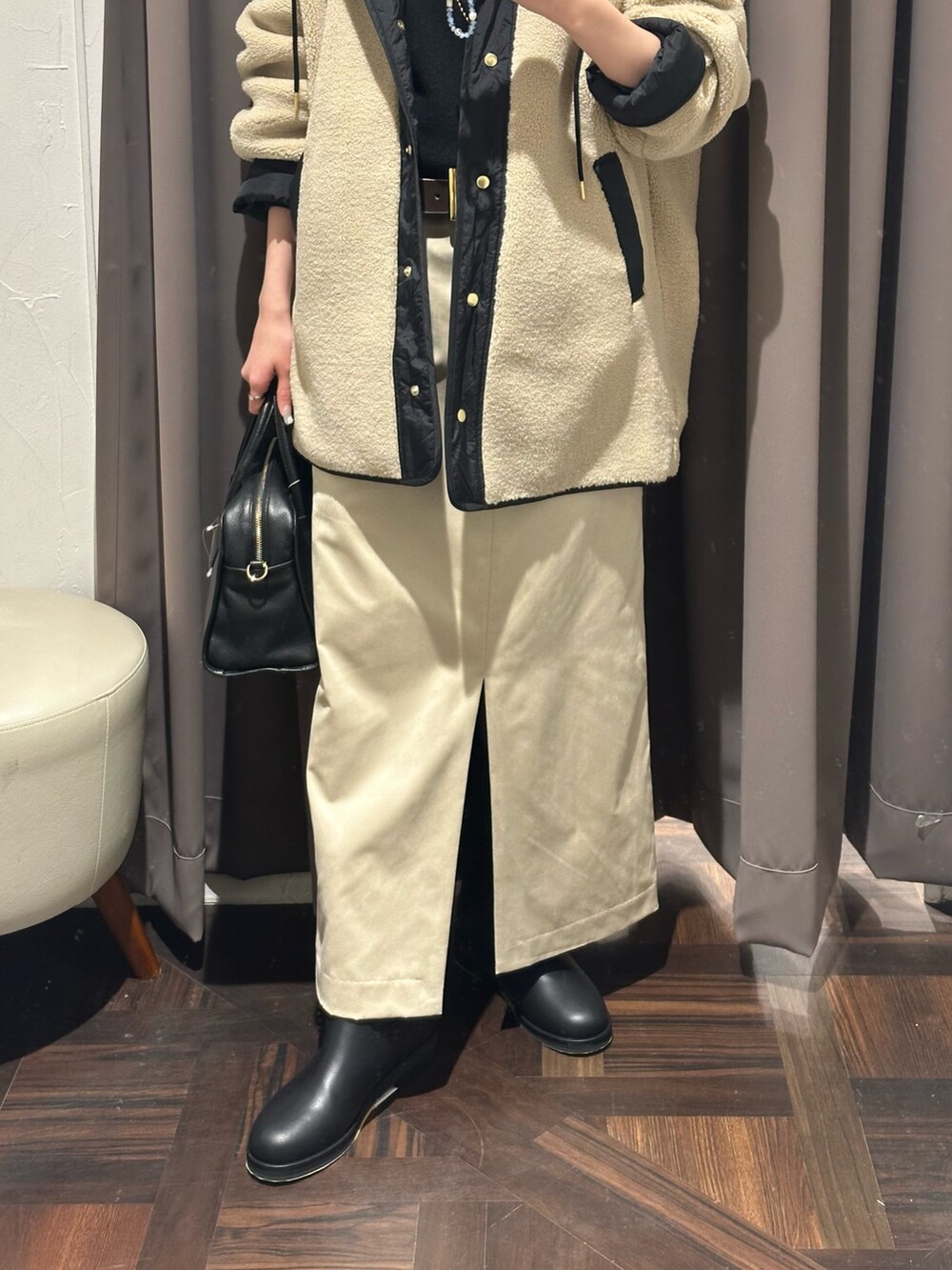 ベージュ系のその他アウター、ベージュ系のスカート、ブラック系のボストンバッグを着用したレディースの秋コーディネートの3枚目の写真