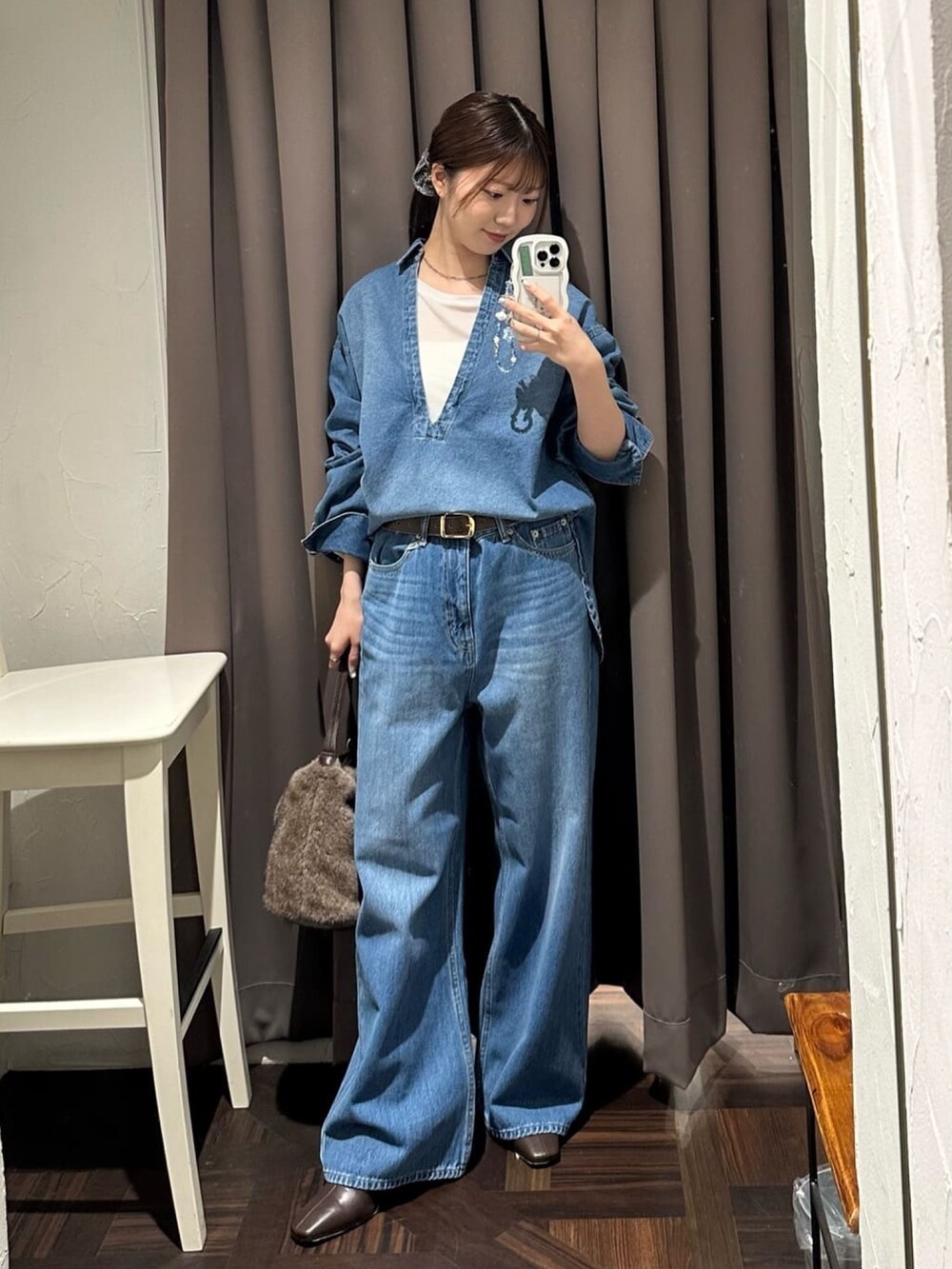 ブルー系のデニムパンツ、ブルー系のシャツ/ブラウス、ブラウン系のハンドバッグを着用したレディースの秋コーディネートの3枚目の写真