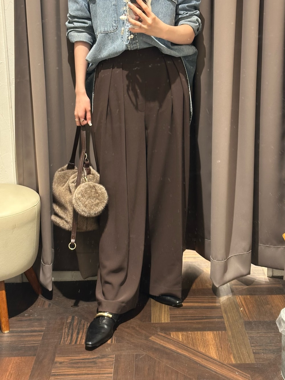 ブラウン系のスラックス、ブルー系のシャツ/ブラウス、ブラウン系のハンドバッグを着用したレディースの秋コーディネートの3枚目の写真