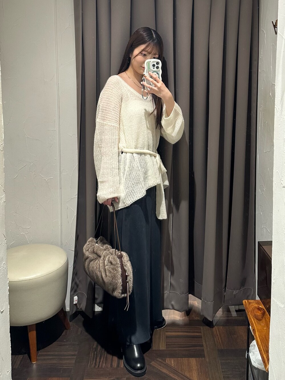 ホワイト系のニット/セーター、ブラック系のブーツ、ブラウン系のハンドバッグを着用したレディースの秋コーディネートの4枚目の写真