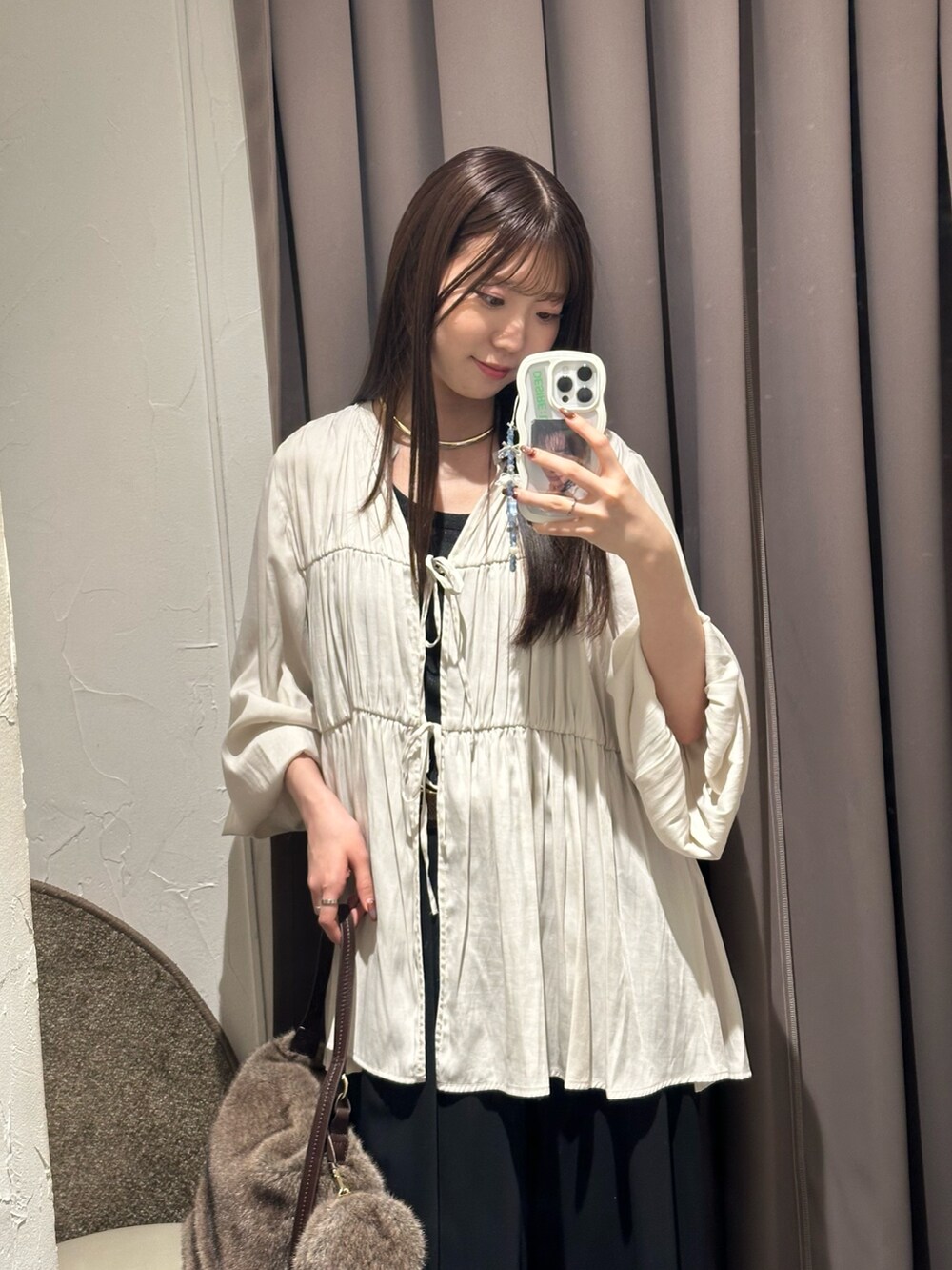 ホワイト系のシャツ/ブラウス、ブラック系のスラックス、ブラウン系のハンドバッグを着用したレディースの秋コーディネートの2枚目の写真