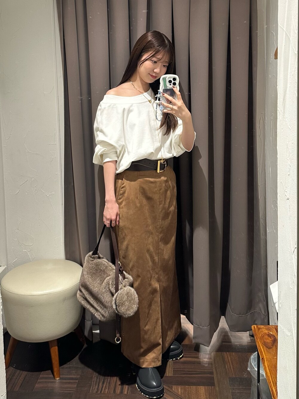 ブラウン系のスカート、ブラウン系のハンドバッグ、ホワイト系のスウェットを着用したレディースの秋コーディネートの4枚目の写真