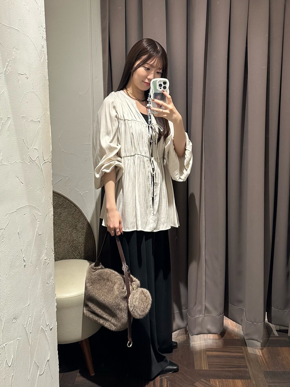 ホワイト系のシャツ/ブラウス、ブラック系のスラックス、ブラウン系のハンドバッグを着用したレディースの秋コーディネートの3枚目の写真