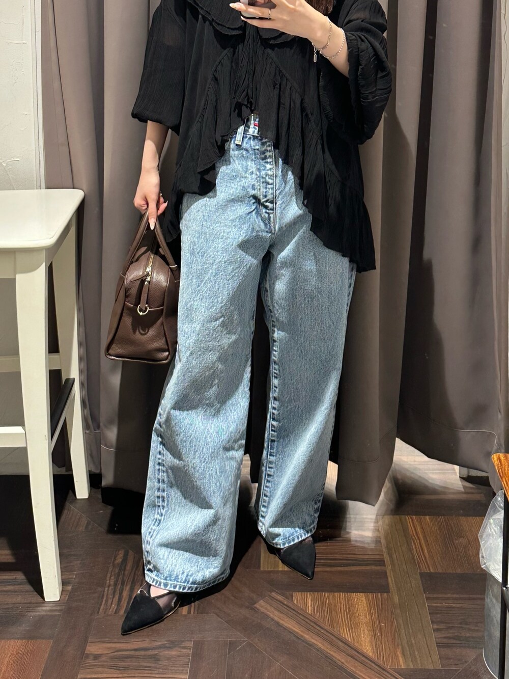 ブルー系のデニムパンツ、ブラック系のシャツ/ブラウス、ブラウン系のボストンバッグを着用したレディースの夏コーディネートの3枚目の写真