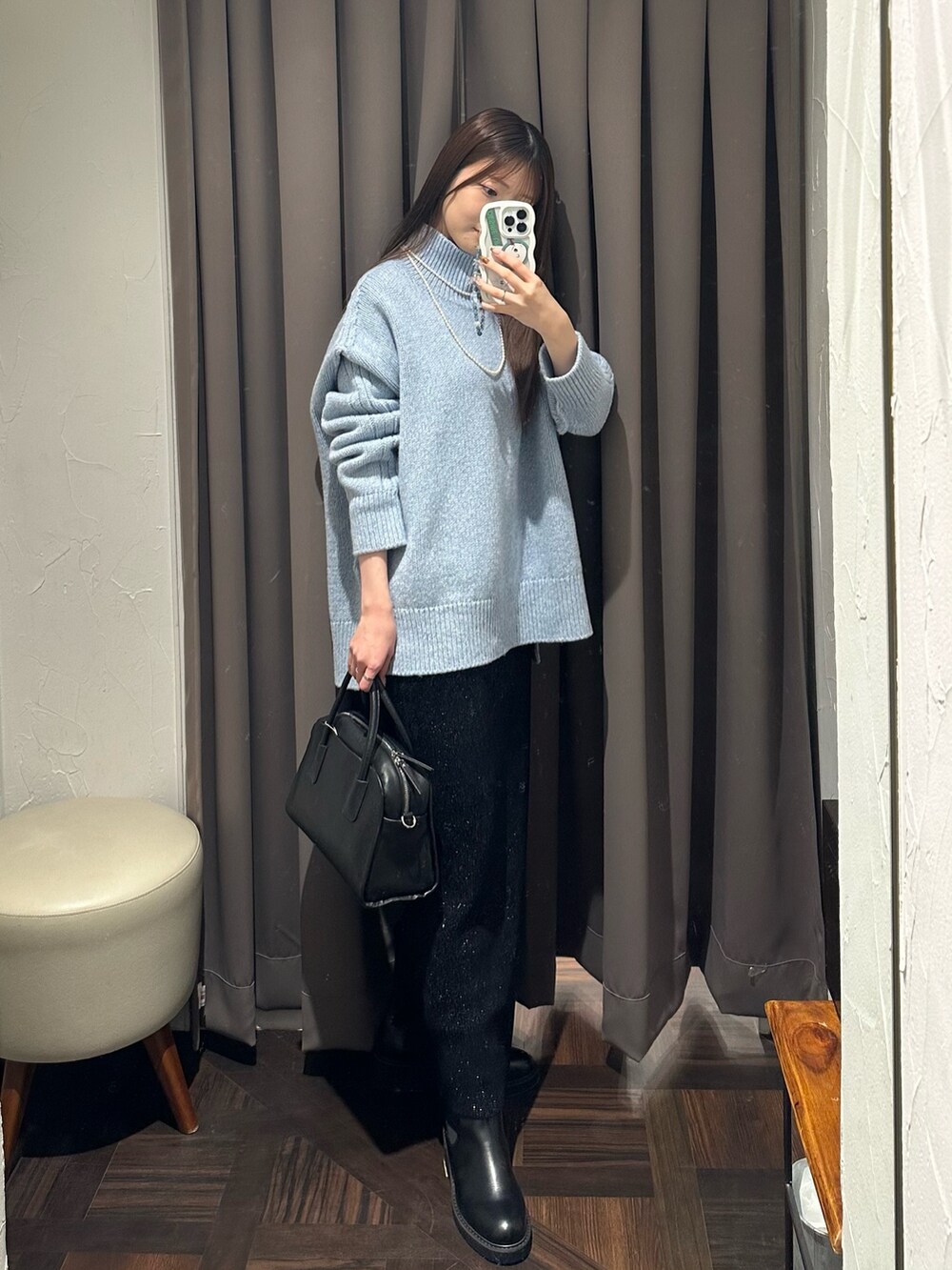 ブルー系のニット/セーター、ブラック系のスカート、ブラック系のブーツを着用したレディースの秋コーディネートの4枚目の写真