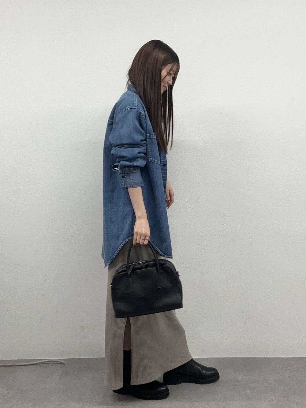 ベージュ系のワンピース、ブラック系のボストンバッグ、ブラック系のブーツを着用したレディースの秋コーディネートの2枚目の写真