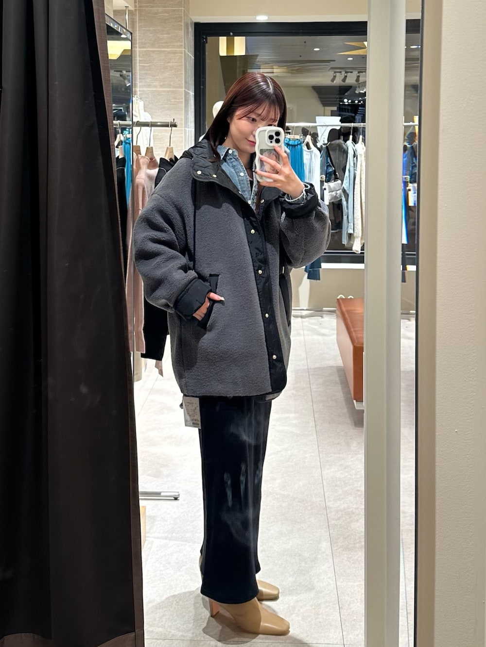 ブラック系のワンピース、グレー系のその他アウター、ベージュ系のブーツを着用したレディースの冬コーディネートの3枚目の写真