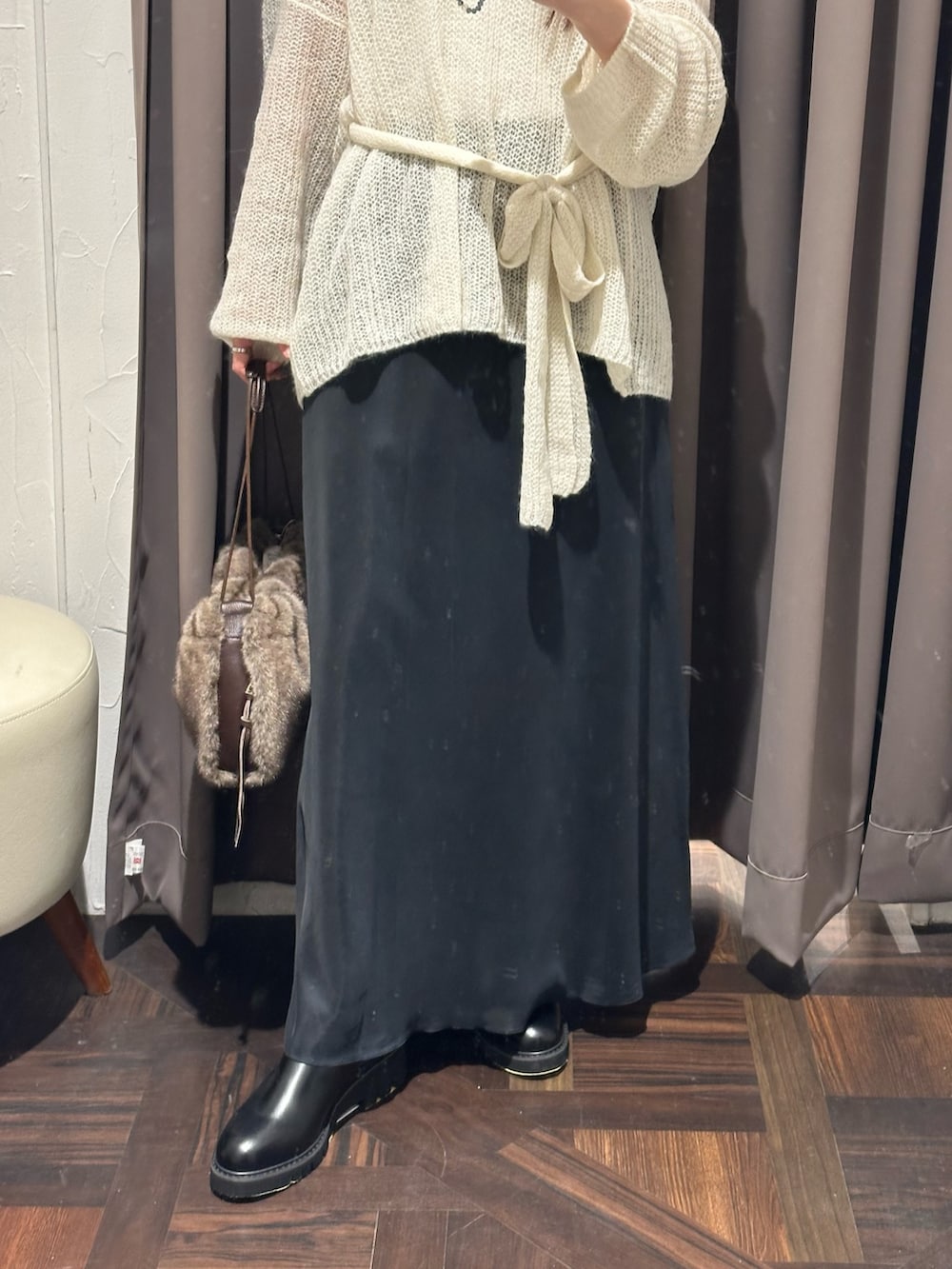 ホワイト系のニット/セーター、ブラック系のブーツ、ブラウン系のハンドバッグを着用したレディースの秋コーディネートの3枚目の写真