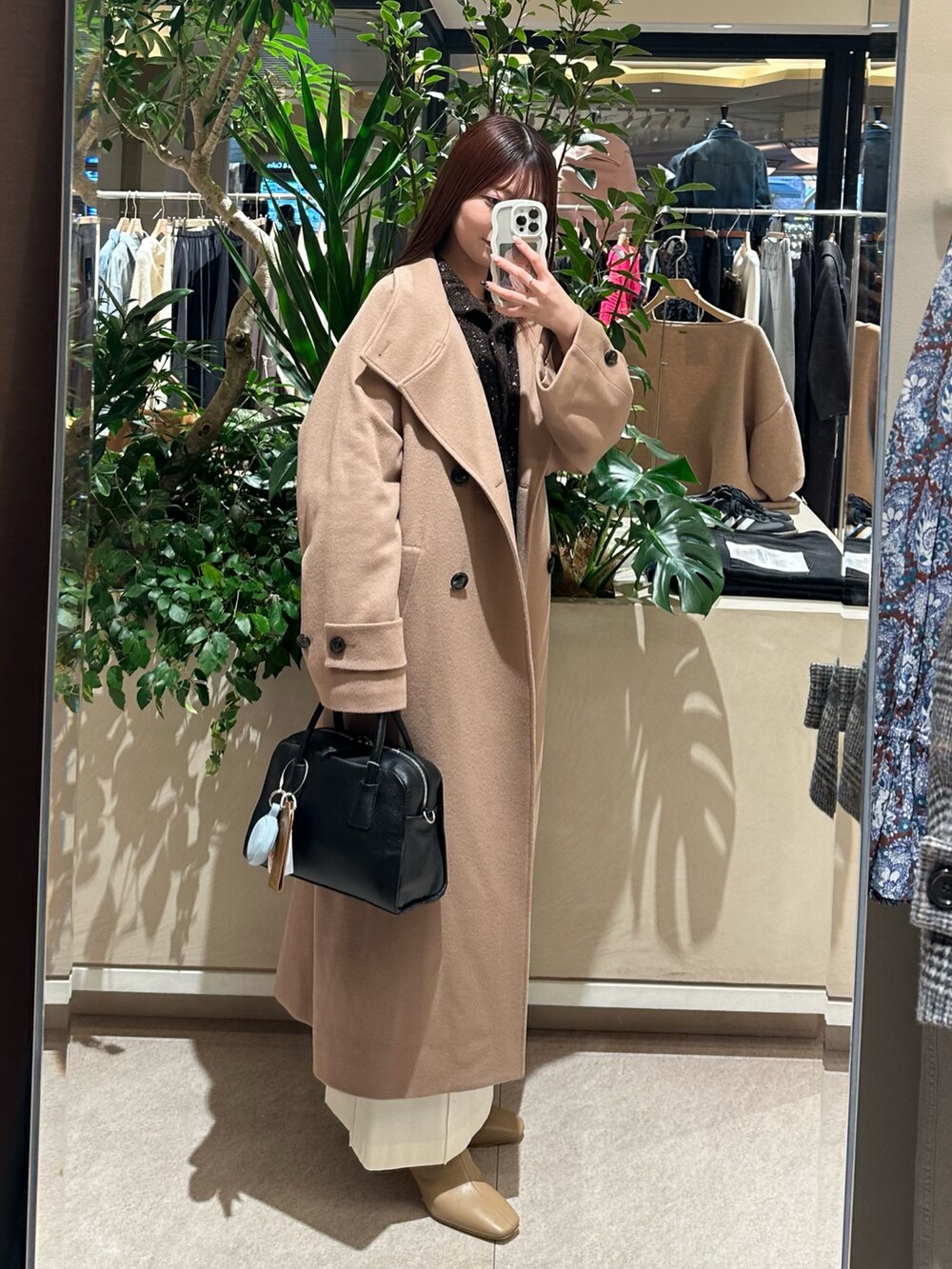 ブラウン系のニット/セーター、ホワイト系のスカート、ベージュ系のブーツを着用したレディースの冬コーディネートの2枚目の写真