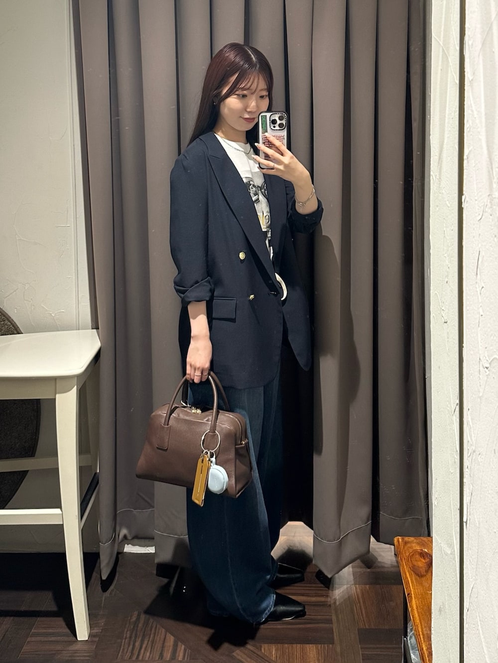 ブルー系のデニムパンツ、ブルー系のテーラードジャケット、ブラウン系のボストンバッグを着用したレディースの夏コーディネートの4枚目の写真