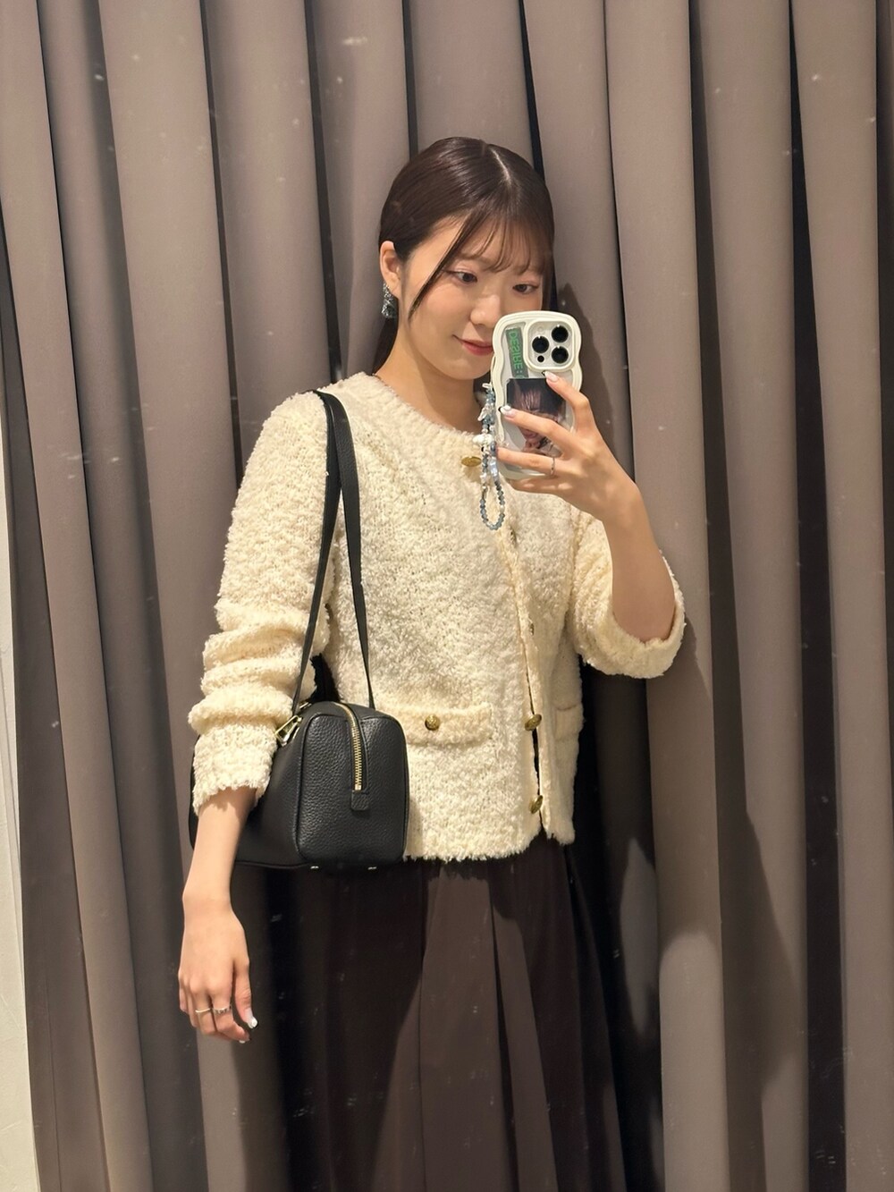 ブラウン系のスラックス、ホワイト系のカーディガン/ボレロ、ブラック系のショルダーバッグを着用したレディースの秋コーディネートの4枚目の写真