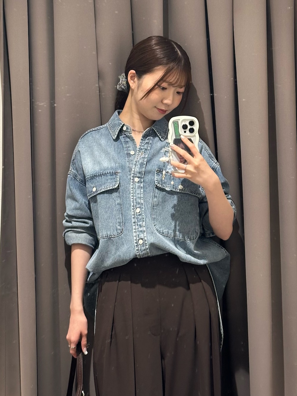 ブラウン系のスラックス、ブルー系のシャツ/ブラウス、ブラウン系のハンドバッグを着用したレディースの秋コーディネートの2枚目の写真