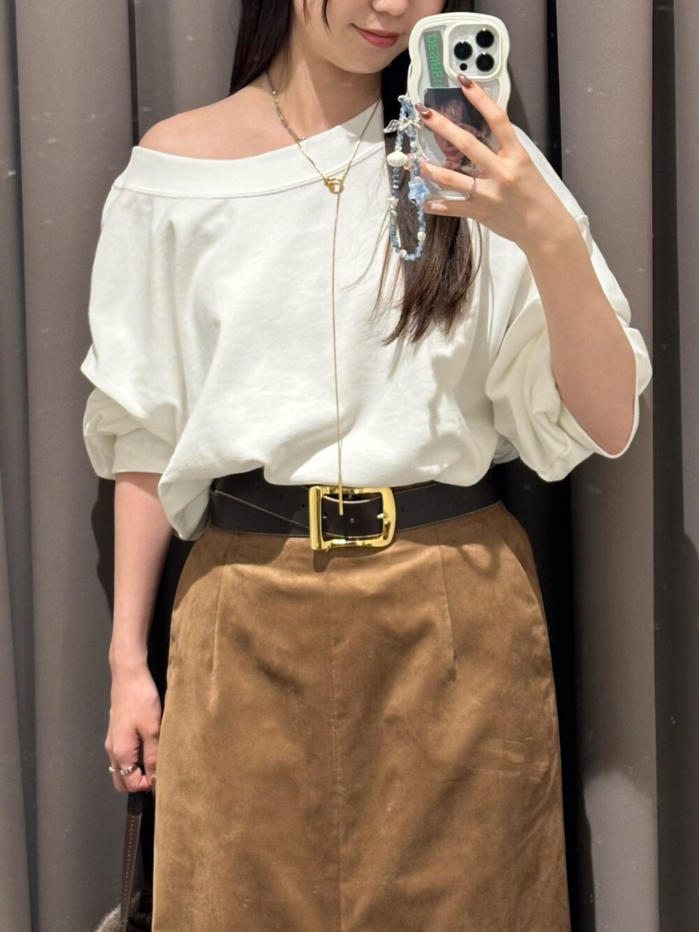 ブラウン系のスカート、ブラウン系のハンドバッグ、ホワイト系のスウェットを着用したレディースの秋コーディネートの3枚目の写真