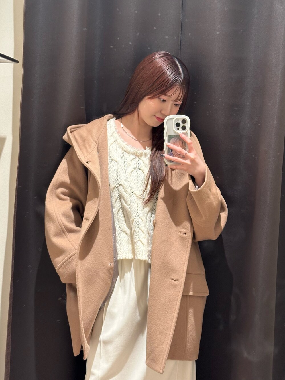 イエロー系のその他アウター、ホワイト系のスカート、ベージュ系のブーツを着用したレディースの冬コーディネートの2枚目の写真