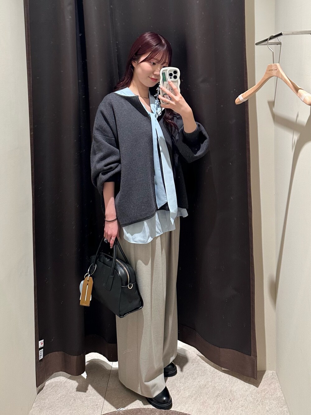 グレー系のニット/セーター、ブルー系のシャツ/ブラウス、ベージュ系のスラックスを着用したレディースの冬コーディネートの3枚目の写真