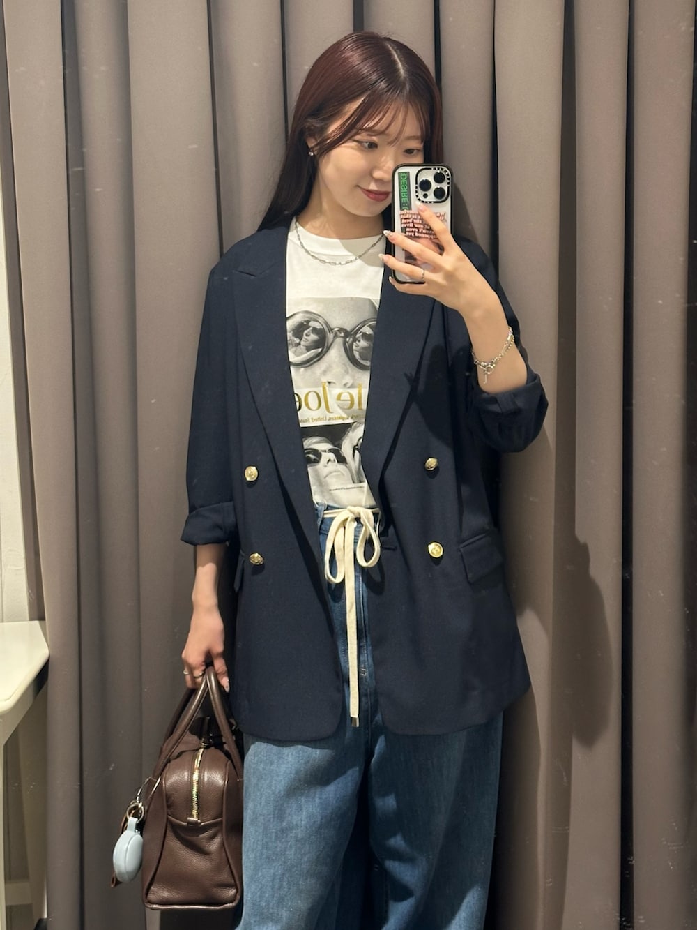 ブルー系のデニムパンツ、ブルー系のテーラードジャケット、ブラウン系のボストンバッグを着用したレディースの夏コーディネートの2枚目の写真