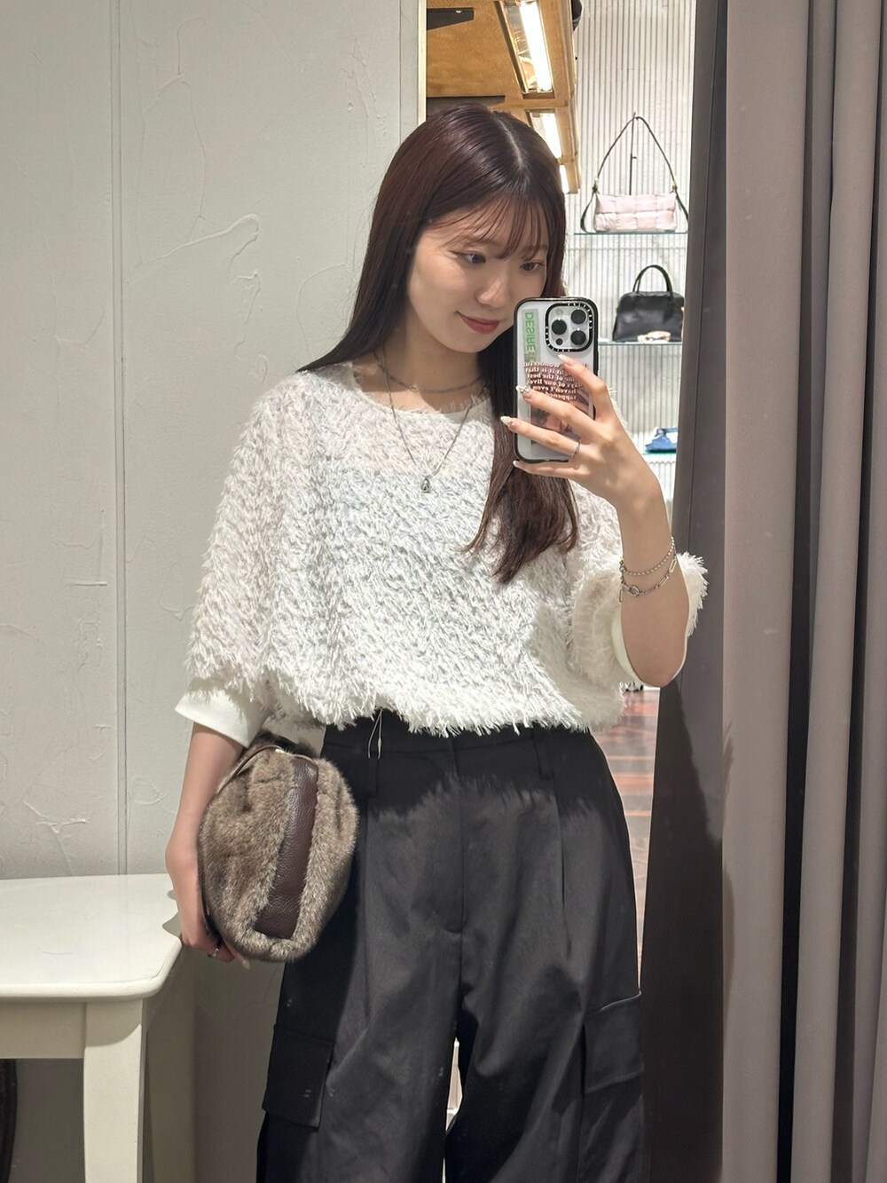 ブラウン系のカーゴパンツ、ホワイト系のシャツ/ブラウス、ブラウン系のハンドバッグを着用したレディースの秋コーディネートの2枚目の写真