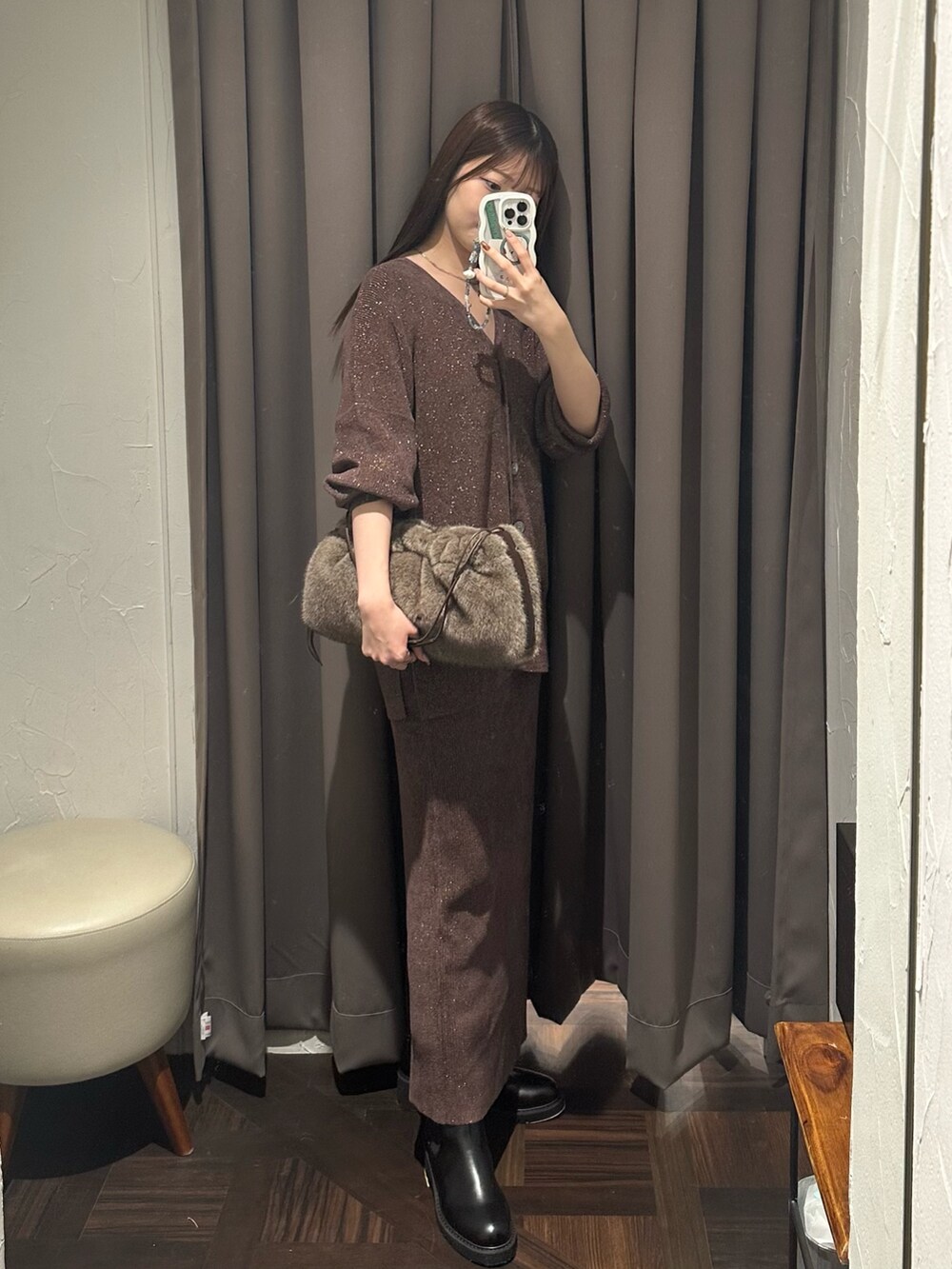 ブラウン系のニット/セーター、ブラウン系のスカート、ブラウン系のハンドバッグを着用したレディースの秋コーディネートの4枚目の写真