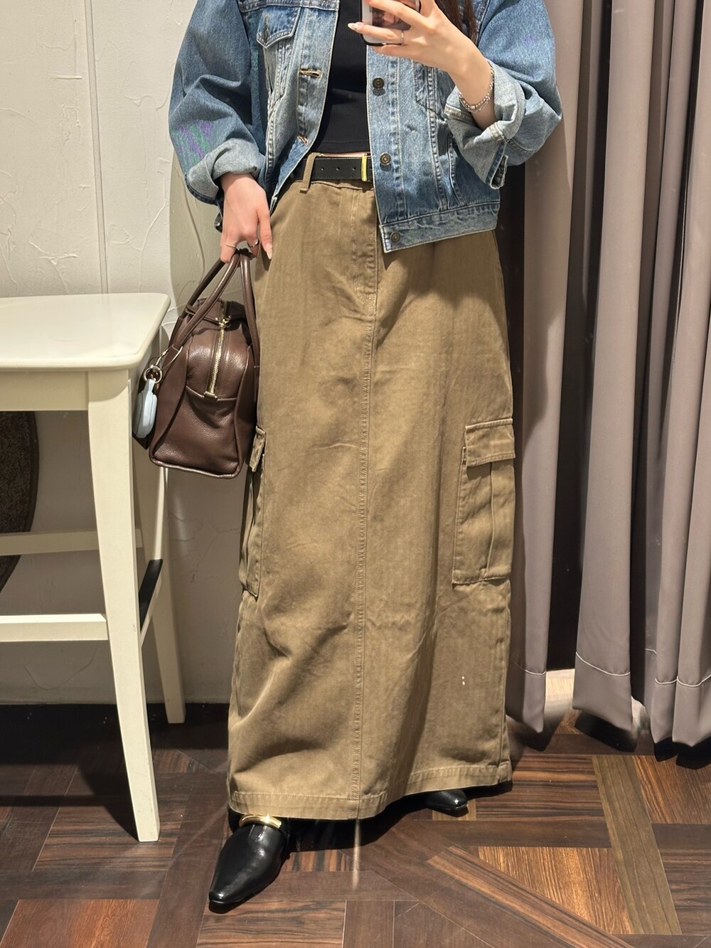 ブラウン系のスカート、ブルー系のデニムジャケット、ブラウン系のボストンバッグを着用したレディースの秋コーディネートの2枚目の写真