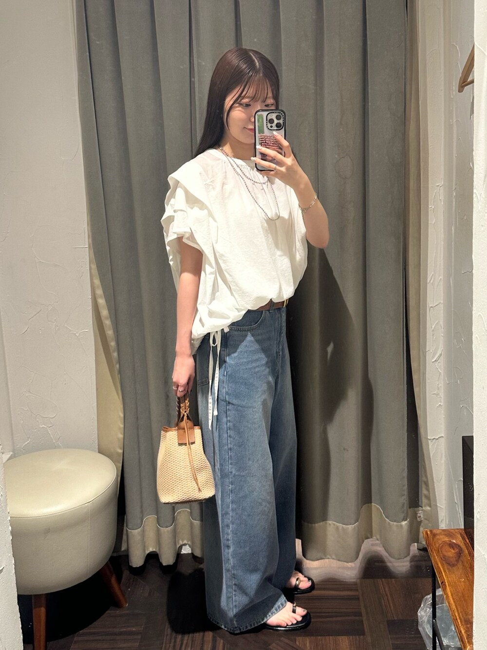 ブルー系のデニムパンツ、ホワイト系のシャツ/ブラウス、ブラウン系のハンドバッグを着用したレディースの夏コーディネートの7枚目の写真