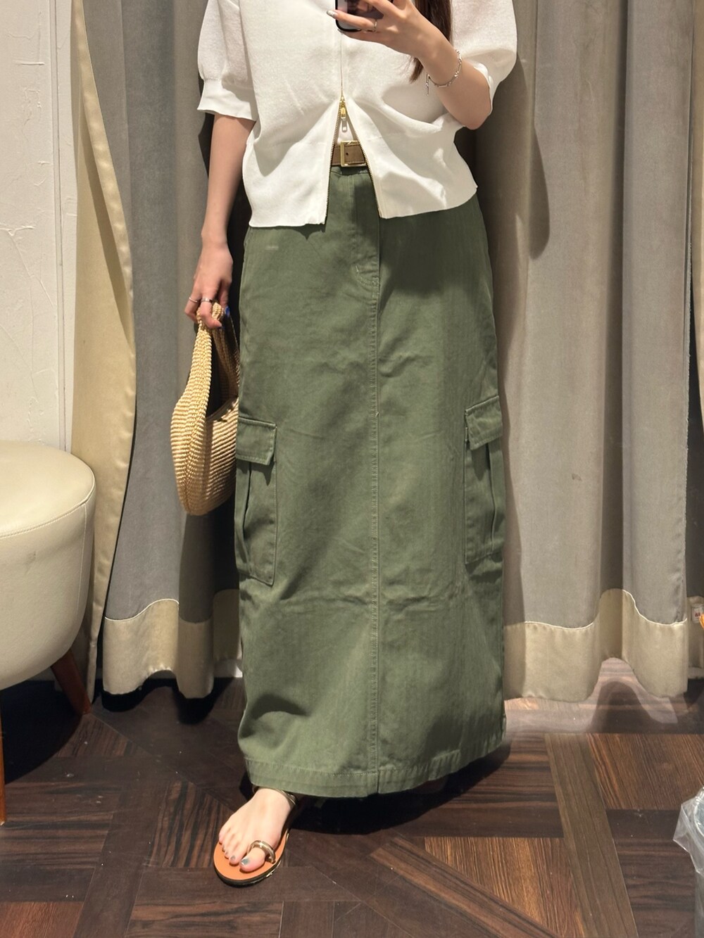 グリーン系のスカート、ホワイト系のパーカーを着用したレディースの夏コーディネートの2枚目の写真