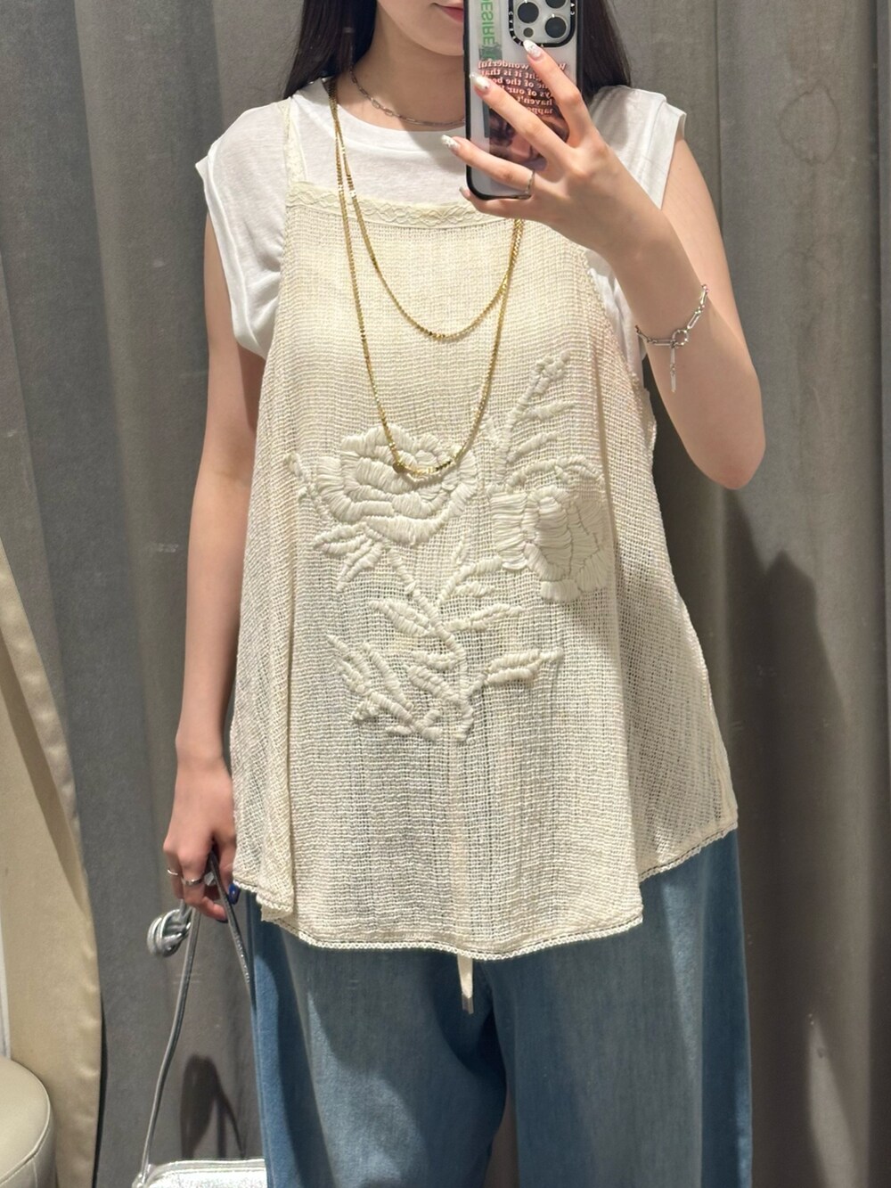 ブルー系のデニムパンツ、ベージュ系のキャミソール、ホワイト系のTシャツ/カットソーを着用したレディースの夏コーディネートの2枚目の写真