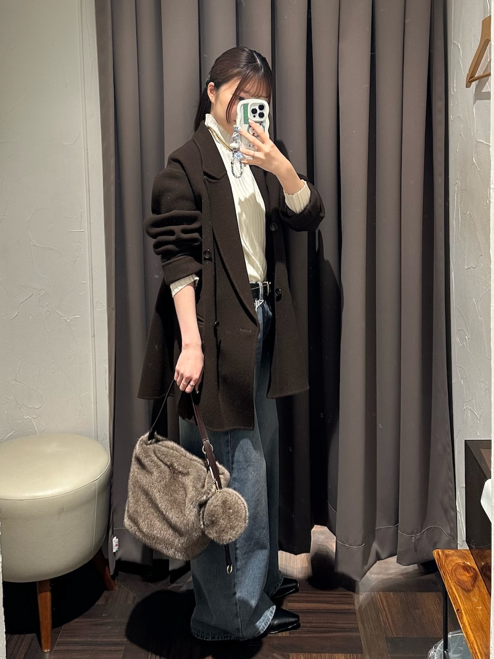 ブラウン系のその他アウター、ホワイト系のニット/セーター、ブラウン系のハンドバッグを着用したレディースの秋コーディネートの2枚目の写真