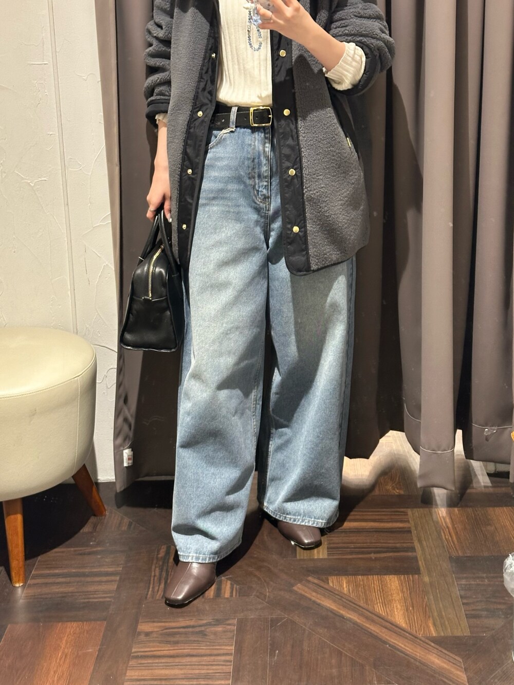 ブルー系のデニムパンツ、グレー系のその他アウター、ブラック系のボストンバッグを着用したレディースの秋コーディネートの3枚目の写真