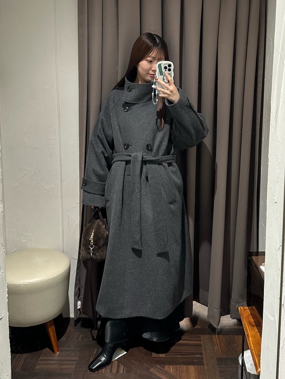 ブラック系のスカート、ホワイト系のTシャツ/カットソー、グレー系のニット/セーターを着用したレディースの冬コーディネートの2枚目の写真