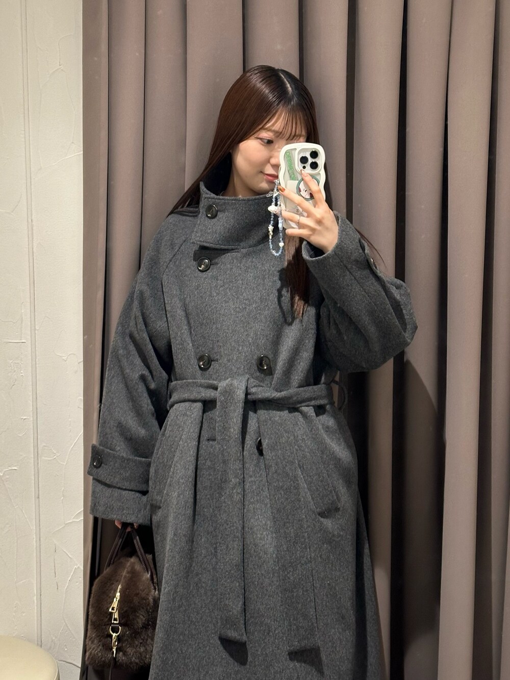 ブラック系のスカート、ホワイト系のTシャツ/カットソー、グレー系のニット/セーターを着用したレディースの冬コーディネートの3枚目の写真