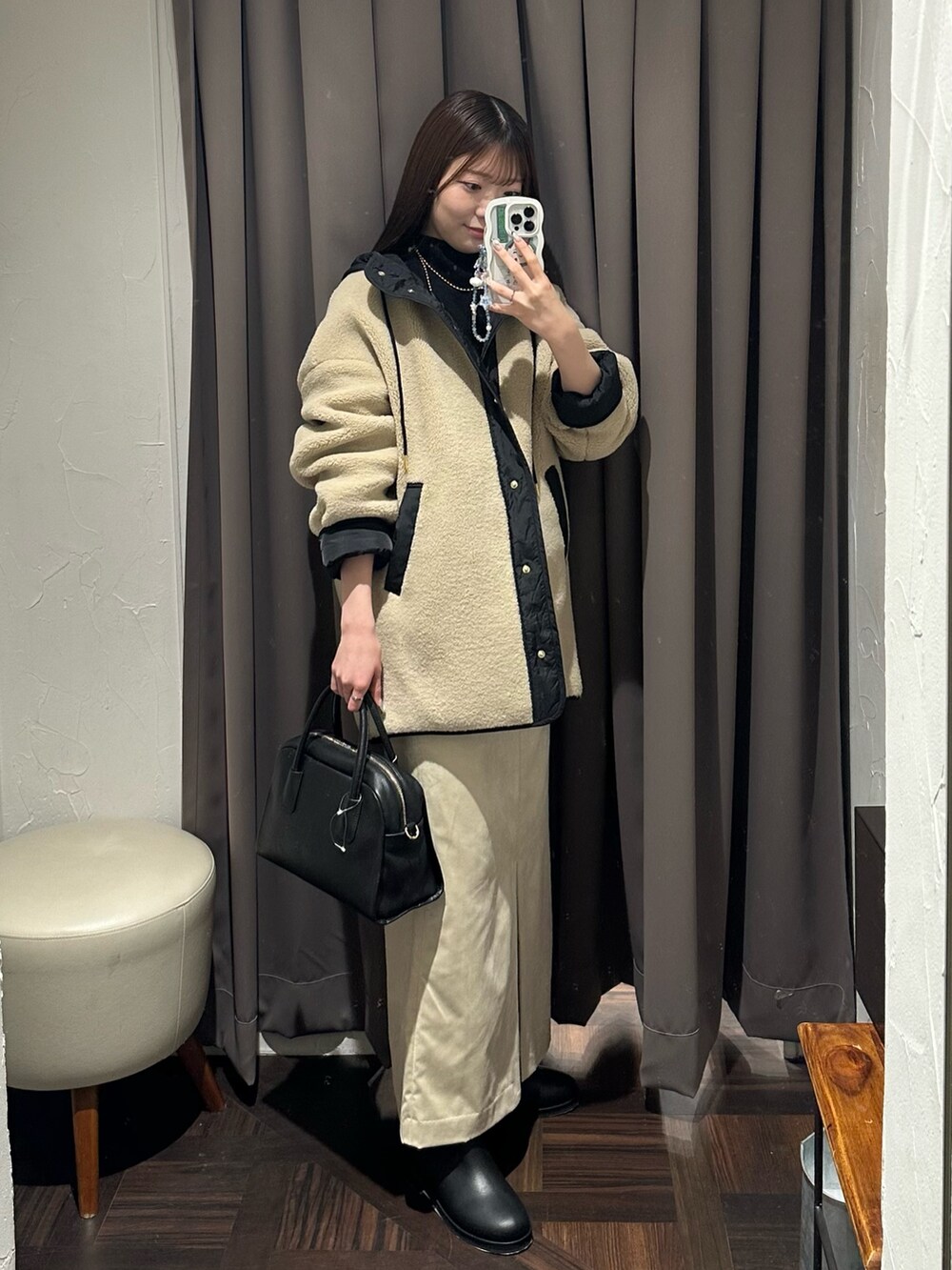 ベージュ系のその他アウター、ベージュ系のスカート、ブラック系のボストンバッグを着用したレディースの秋コーディネートの4枚目の写真