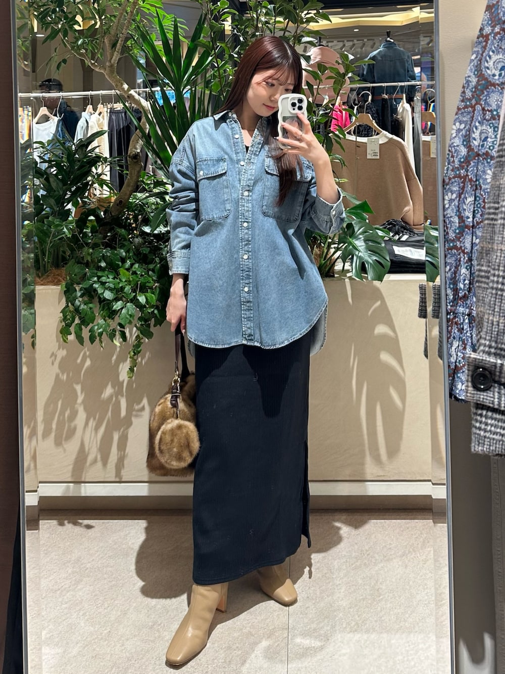 ブラック系のワンピース、グレー系のその他アウター、ベージュ系のブーツを着用したレディースの冬コーディネートの4枚目の写真