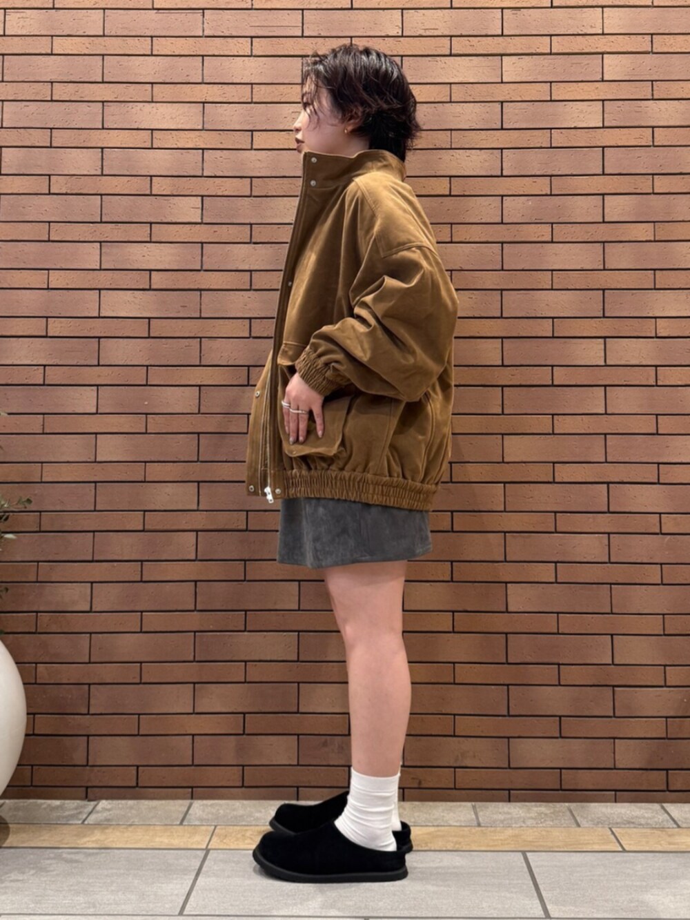 ブラック系のスリッポン、グレー系のTシャツ/カットソー、ブラウン系のブルゾンを着用したレディースの秋コーディネートの3枚目の写真