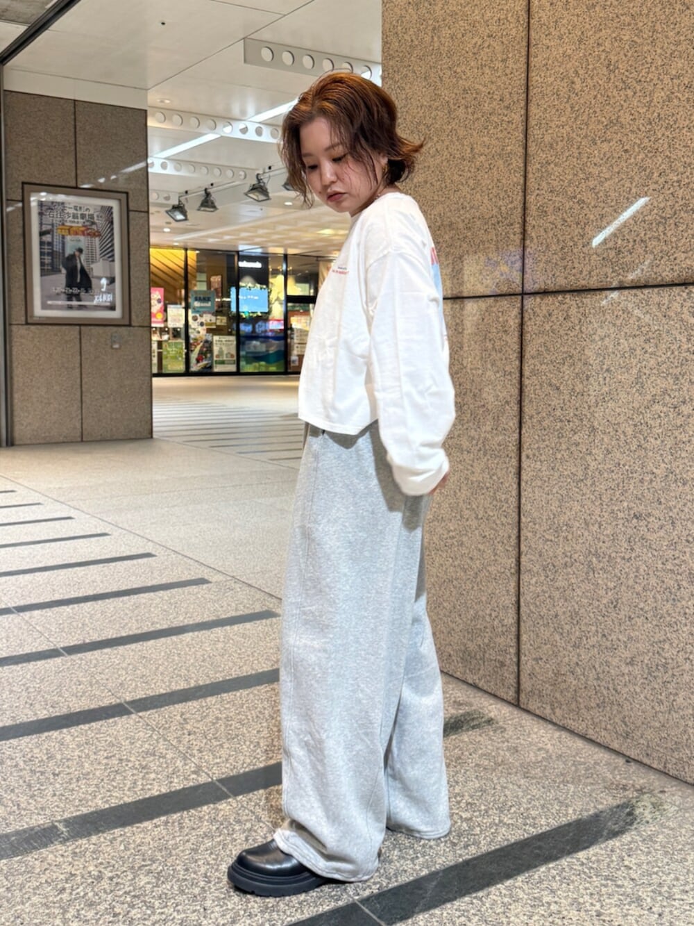 ホワイト系のTシャツ/カットソー、シルバー系のハンドバッグ、グレー系のスウェットパンツを着用したレディースの冬コーディネートの2枚目の写真