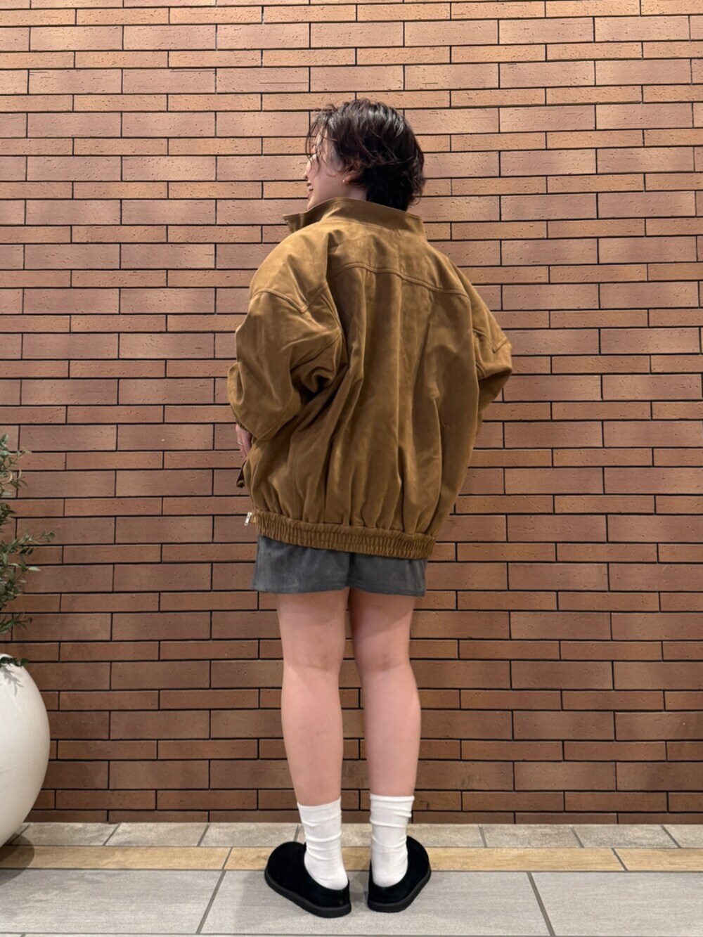 ブラック系のスリッポン、グレー系のTシャツ/カットソー、ブラウン系のブルゾンを着用したレディースの秋コーディネートの4枚目の写真